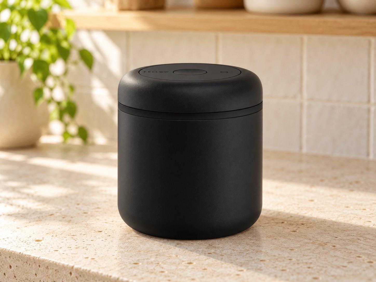 Fellow Atmos vacuum canister in matte black on a kitchen counter